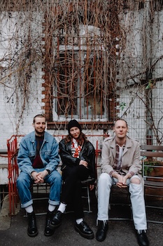 Alex, Lisa und Kenne sitzen nebeneinander in einem Hinterhof in Nürnberg